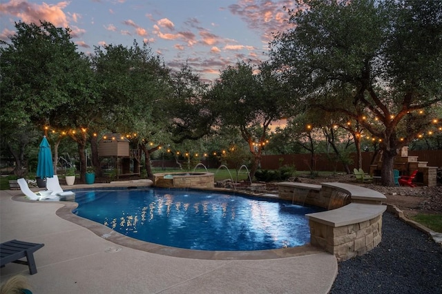 pool at dusk with a fenced in pool, a fenced backyard, an in ground hot tub, and a patio area