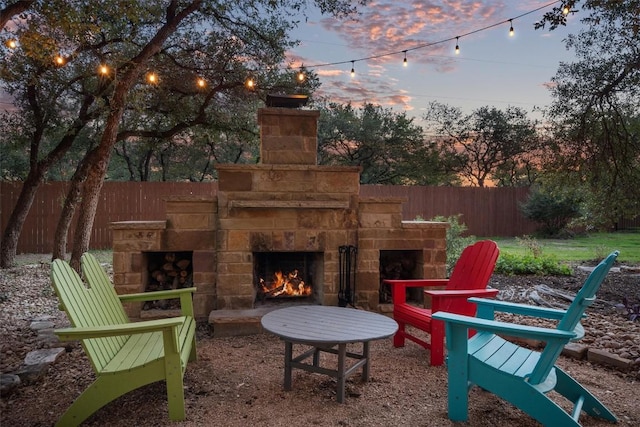 view of patio with fence and an outdoor stone fireplace