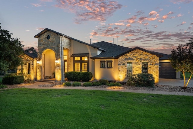 view of front of house featuring a garage, a front yard, stone siding, and concrete driveway