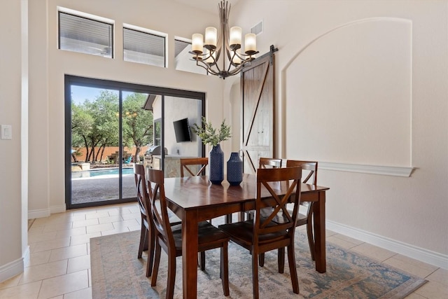 dining area with an inviting chandelier, a barn door, baseboards, light tile patterned floors, and visible vents