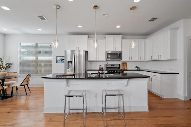 907 Totis Rd, Austin, TX 78748 - kitchen featuring stainless steel appliances, dark countertops, decorative backsplash, a breakfast bar, and recessed lighting