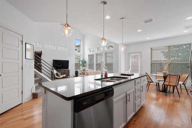 907 Totis Rd, Austin, TX 78748 - kitchen with stainless steel dishwasher, light wood finished floors, decorative light fixtures, and recessed lighting