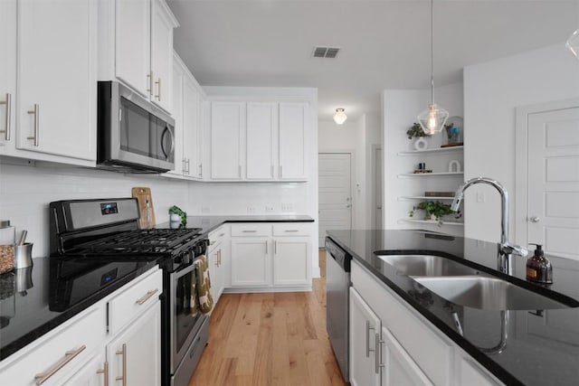 kitchen featuring a sink, appliances with stainless steel finishes, white cabinetry, and visible vents