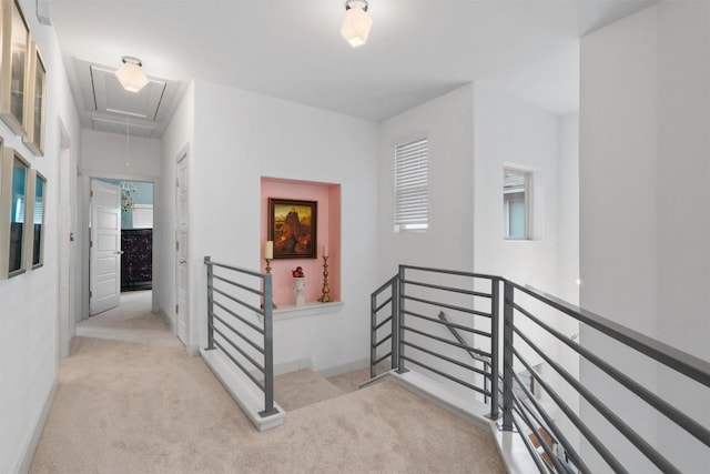 corridor with baseboards, carpet, attic access, and an upstairs landing