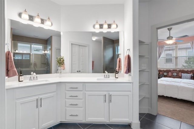 ensuite bathroom featuring ceiling fan, a shower stall, a sink, and tile patterned flooring