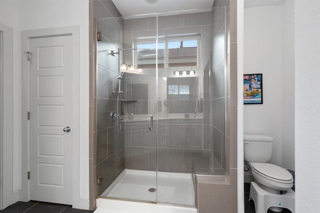 bathroom with toilet, tile patterned floors, and a stall shower