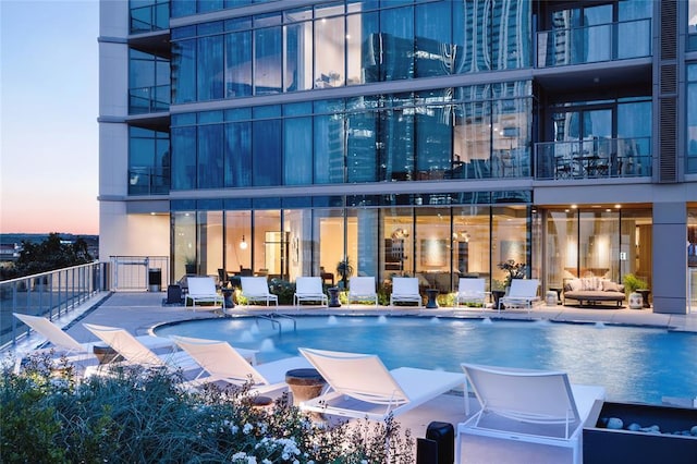 pool at dusk with a community pool