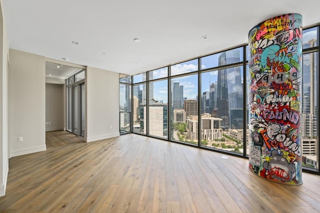 501 W Ave Unit 2001, Austin, TX 78701 - spare room featuring hardwood / wood-style flooring, floor to ceiling windows, plenty of natural light, a skyline view, and baseboards