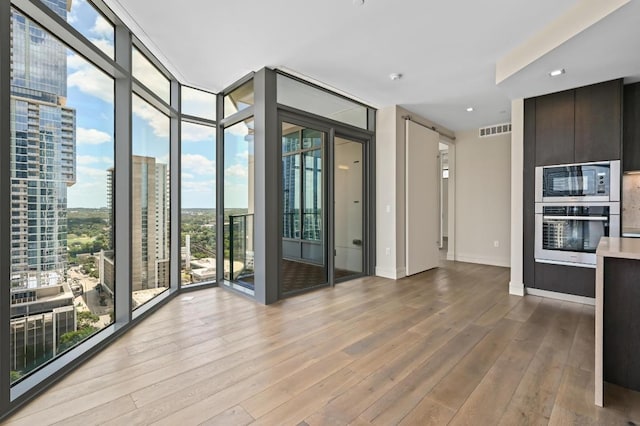 501 W Ave Unit 2001, Austin, TX 78701 - unfurnished room featuring wood finished floors, expansive windows, baseboards, and a city view