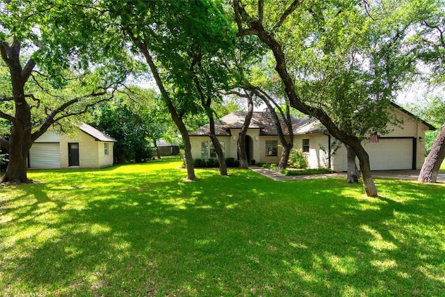 view of yard featuring driveway and a garage