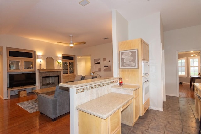 kitchen with baseboards, a ceiling fan, light brown cabinetry, and white appliances