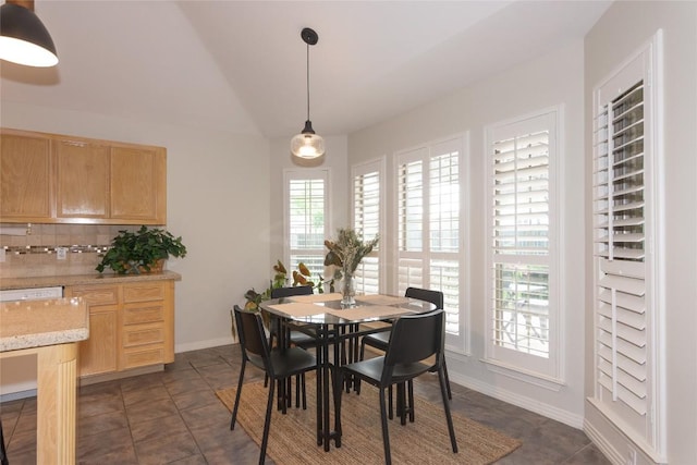 dining room with baseboards and vaulted ceiling