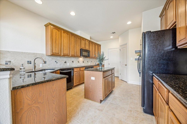 kitchen featuring a center island, dark stone counters, tasteful backsplash, a sink, and black appliances