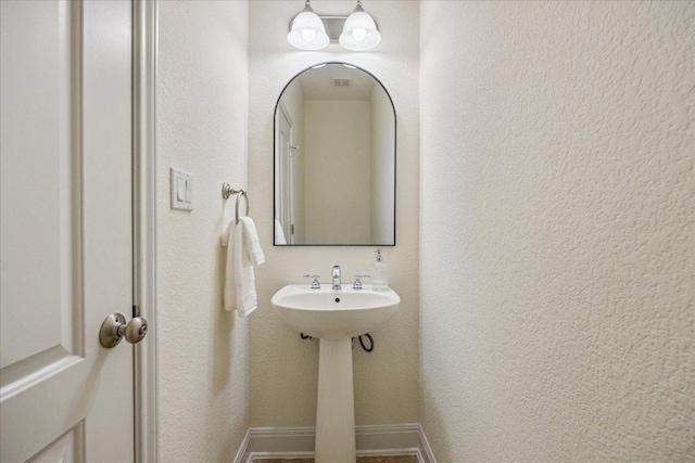 bathroom with a sink and baseboards