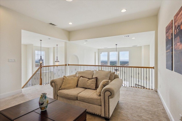 living room featuring a healthy amount of sunlight, baseboards, carpet flooring, and visible vents