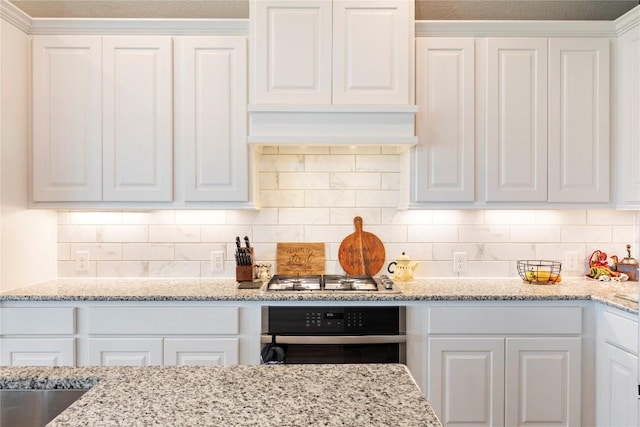 3105 High Meadow St, Seguin, TX 78155 - kitchen with appliances with stainless steel finishes, white cabinetry, decorative backsplash, and light stone countertops