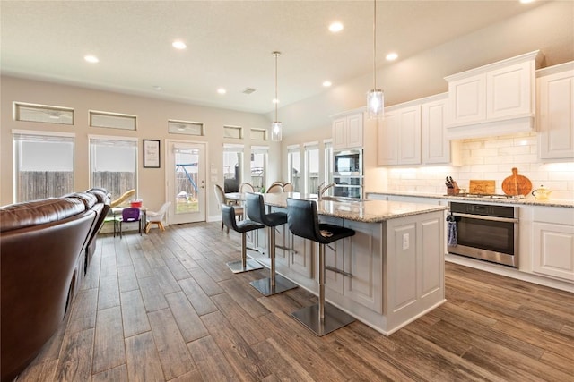 3105 High Meadow St, Seguin, TX 78155 - kitchen featuring stainless steel appliances, recessed lighting, dark wood-style floors, backsplash, and a kitchen breakfast bar