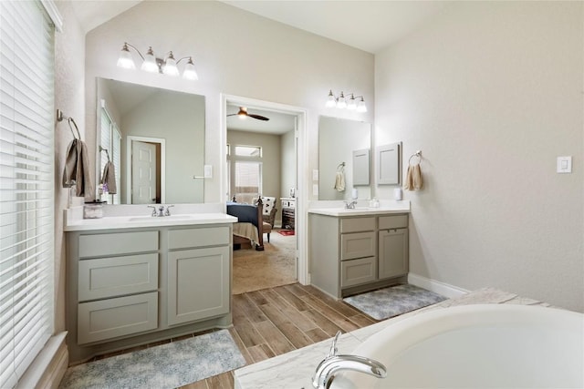 3105 High Meadow St, Seguin, TX 78155 - ensuite bathroom featuring wood finished floors, two vanities, ceiling fan, a tub, and baseboards