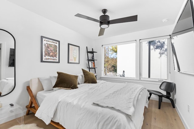 bedroom featuring light wood-type flooring, baseboards, and ceiling fan