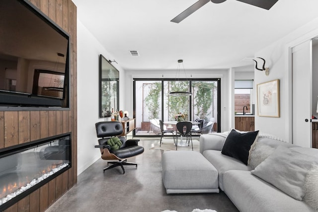 631 Tillery St Unit 1, Austin, TX 78702 - living room featuring finished concrete flooring, a glass covered fireplace, and ceiling fan