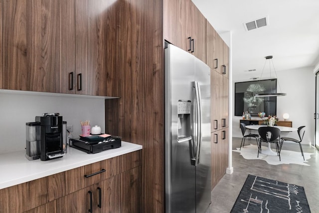 631 Tillery St Unit 1, Austin, TX 78702 - kitchen with stainless steel fridge, finished concrete floors, modern cabinets, light countertops, and pendant lighting