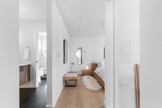 corridor featuring baseboards and wood finished floors
