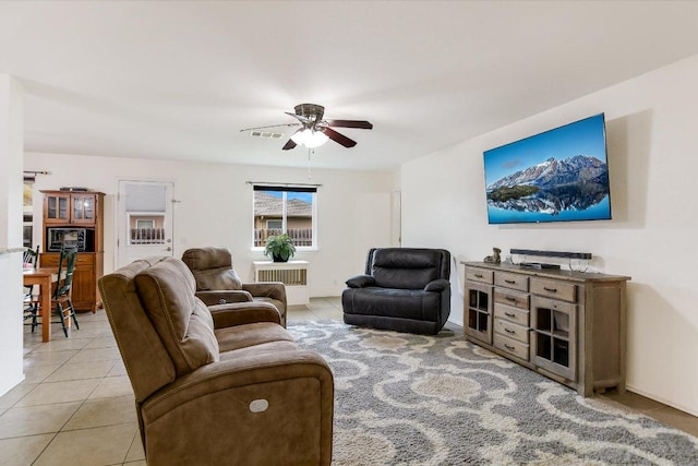 living area featuring light tile patterned floors and a ceiling fan