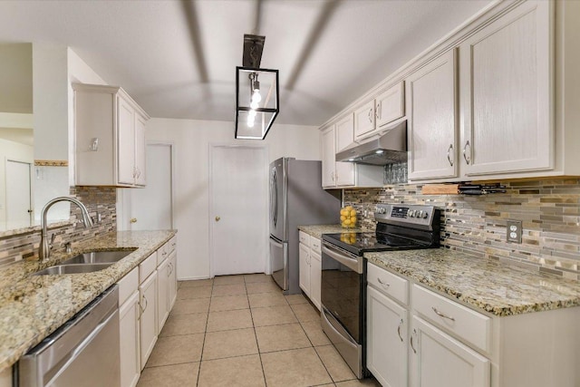 3006 Tyler Ln, Taylor, TX 76574 - kitchen featuring appliances with stainless steel finishes, a sink, under cabinet range hood, decorative backsplash, and white cabinetry