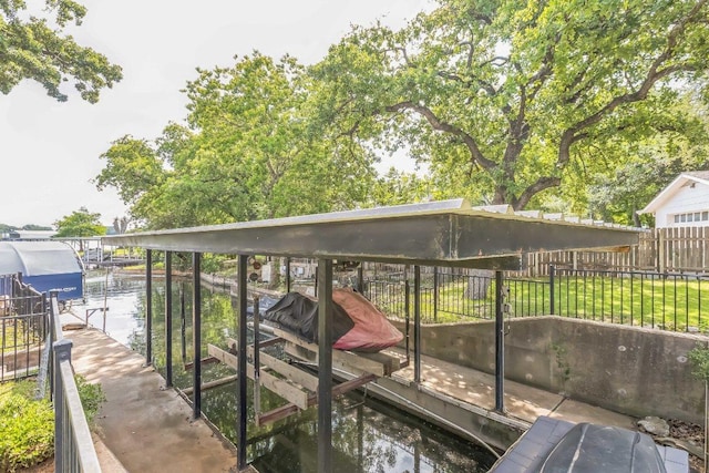 view of dock with boat lift, fence, and a water view