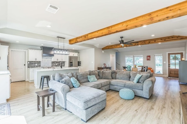 living room with recessed lighting, visible vents, plenty of natural light, and light wood-style flooring