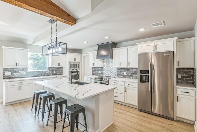 kitchen with decorative backsplash, a kitchen breakfast bar, custom range hood, a sink, and stainless steel appliances
