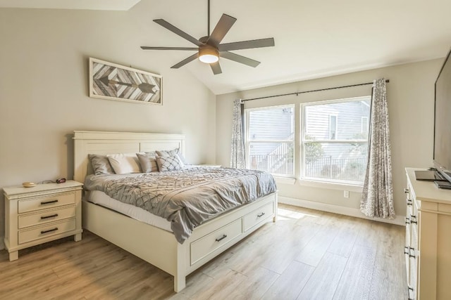 bedroom with baseboards, light wood finished floors, ceiling fan, and lofted ceiling