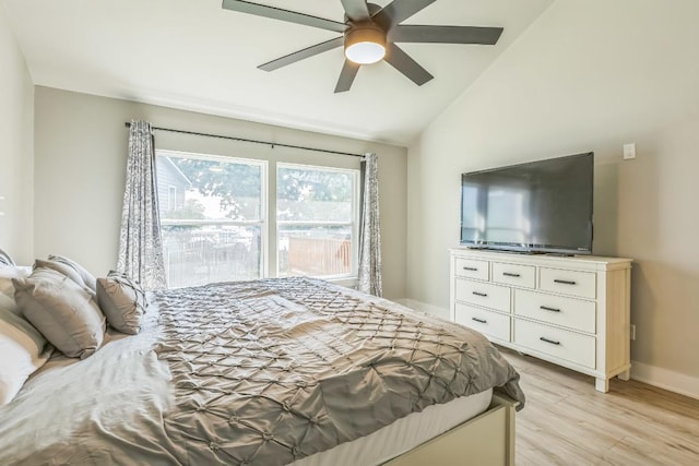 bedroom with baseboards, ceiling fan, light wood-style flooring, and lofted ceiling