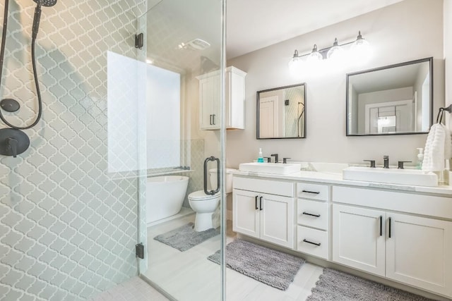 bathroom featuring double vanity, tile patterned floors, a sink, and a stall shower