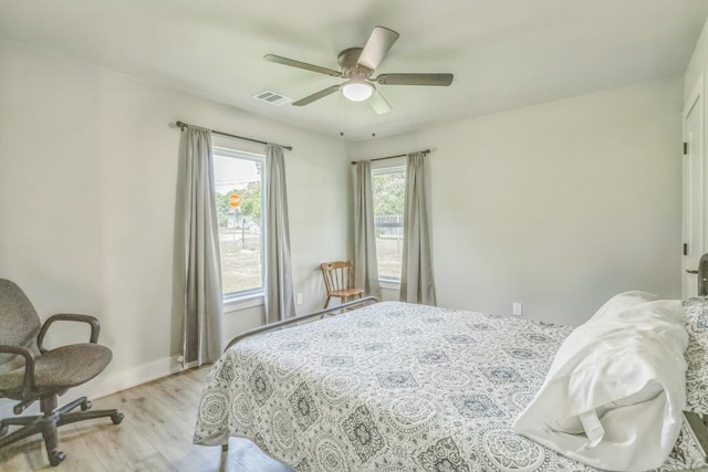 bedroom with baseboards, ceiling fan, light wood finished floors, and visible vents