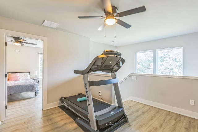 exercise area featuring baseboards, a ceiling fan, light wood-style flooring, and visible vents
