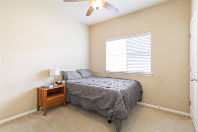bedroom featuring baseboards, a ceiling fan, and light carpet