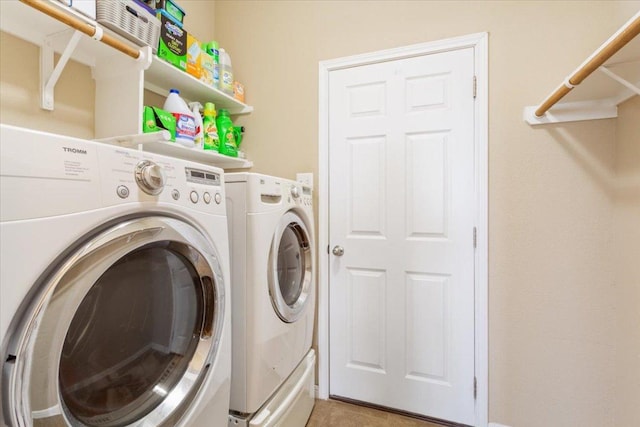 laundry room featuring laundry area, light tile patterned floors, and washing machine and dryer