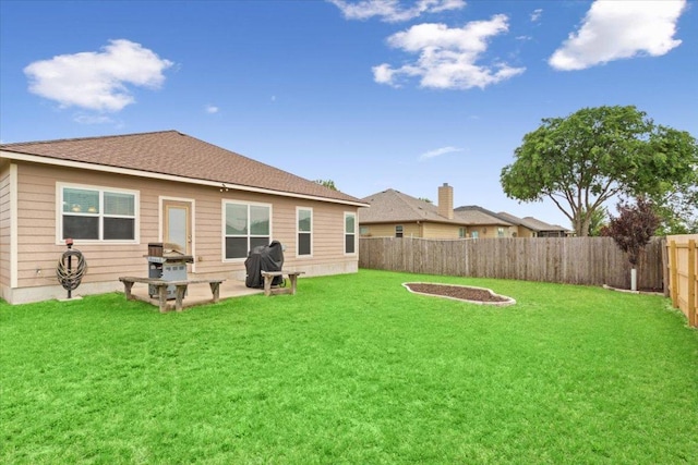 back of house with a yard, a patio, and a fenced backyard
