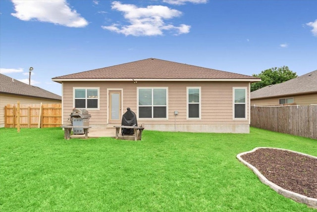 rear view of house featuring a fenced backyard, a patio area, and a yard