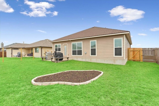 rear view of property with a lawn and a fenced backyard