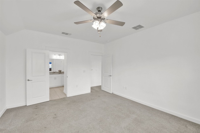 unfurnished bedroom with light colored carpet, baseboards, visible vents, and ensuite bathroom