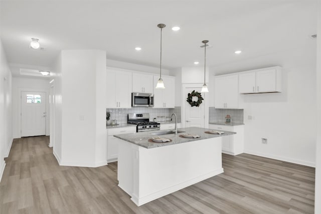 kitchen with tasteful backsplash, stainless steel appliances, and light wood-type flooring