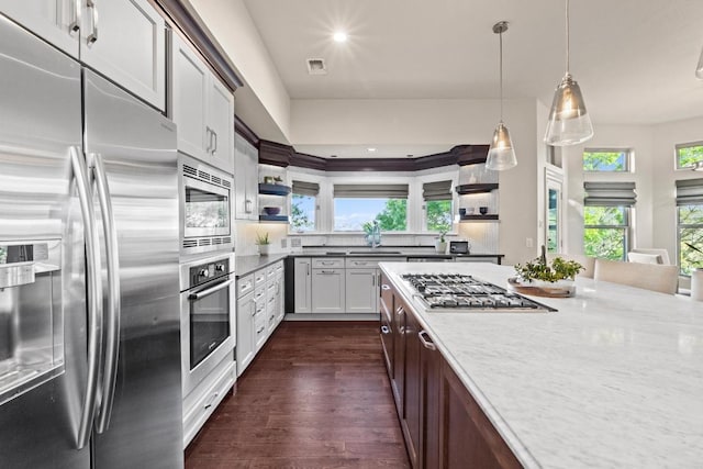 5705 Puccoon Cv, Austin, TX 78759 - kitchen with appliances with stainless steel finishes, open shelves, dark wood-style flooring, pendant lighting, and tasteful backsplash