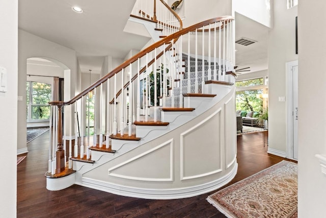 5705 Puccoon Cv, Austin, TX 78759 - stairs featuring arched walkways, wood finished floors, recessed lighting, baseboards, and a towering ceiling