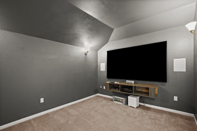 carpeted home theater featuring baseboards and lofted ceiling