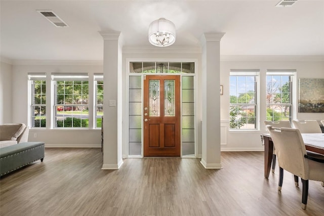 2045 Saint Andrews Dr, Round Rock, TX 78664 - entryway with ornamental molding, ornate columns, a chandelier, and wood finished floors