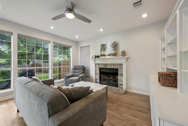 2045 Saint Andrews Dr, Round Rock, TX 78664 - living area featuring wood finished floors, ceiling fan, a fireplace with raised hearth, and recessed lighting