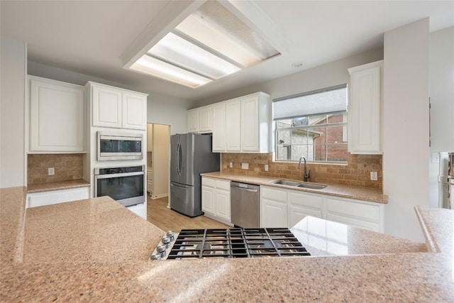 2045 Saint Andrews Dr, Round Rock, TX 78664 - kitchen with appliances with stainless steel finishes, white cabinetry, backsplash, and light wood-style flooring