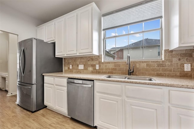 2045 Saint Andrews Dr, Round Rock, TX 78664 - kitchen with appliances with stainless steel finishes, white cabinetry, light wood-type flooring, light countertops, and decorative backsplash